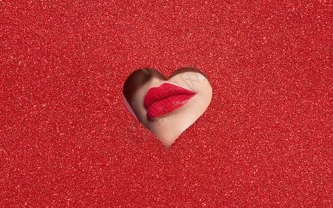 爱学之心个年轻漂亮的女人用红色口红的美丽丰满明亮的嘴唇,看着由彩色纸制成的心形图案假日模式情人节美丽的爱情化妆背景
