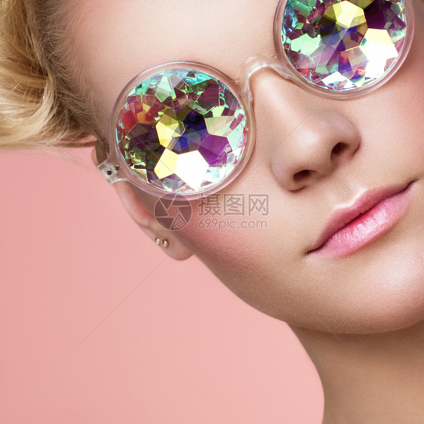 戴着彩色眼镜的美丽年轻女人的肖像美容时尚完美的化妆五颜六色的装饰全息太阳镜珊瑚色图片