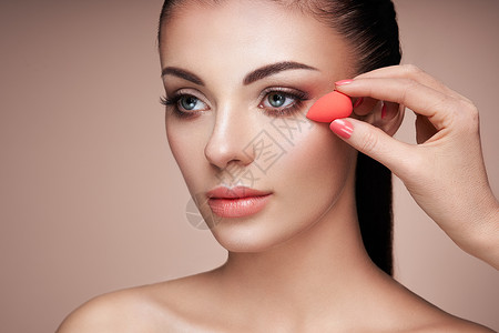 化妆师应用斯金通漂亮的女人脸完美的妆容护肤基金会海绵化妆师图片
