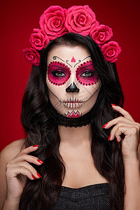 墨西哥玫瑰红色背景上有糖头盖骨化妆的女人的肖像万圣节服装化妆卡拉韦拉卡特里娜的肖像背景
