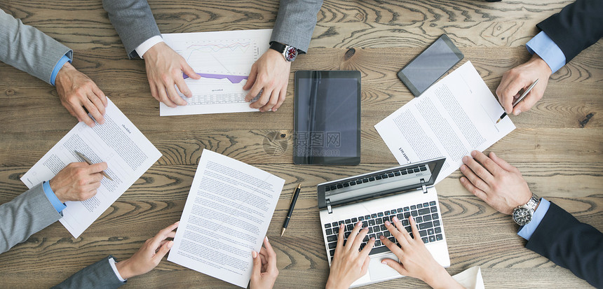 业务队与合同,财务报告笔记本电脑讨论交易坐办公室桌子周围业务队与合同合作图片
