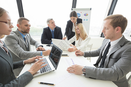 商务人员会议上坐办公室桌子周围讨论文件办公室桌子上的商务会议图片