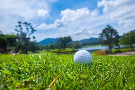 球场上的高尔夫球,背景上有湖山的美丽景观球场上的高尔夫球图片