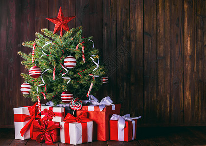 装饰圣诞树木制背景上的礼品盒装饰圣诞树图片