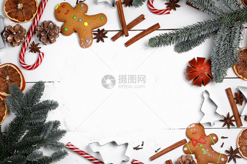 圣诞装饰食品框架姜饼饼干,香料,糖果罐头冷杉树枝雪白的背景上,有圣诞装饰框架图片