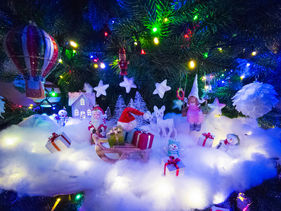 美丽的发光圣诞树,有许多礼物盒装饰雪地上圣诞树下的圣诞装饰图片