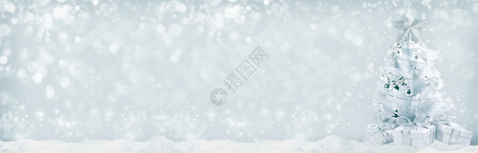 白色圣诞树,银色装饰礼物雪地上的Bokeh背景圣诞树礼物背景图片