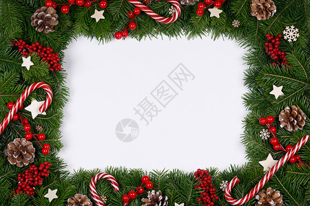 白纸糖果边框圣诞边框的树枝白色背景与隔离,红白装饰,浆果,星星,锥圣诞树树枝的圣诞框架背景