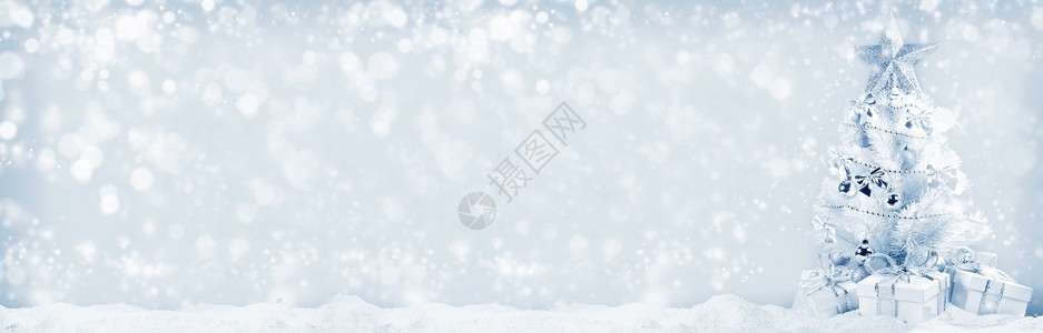 白色圣诞树,银色装饰礼物雪地上的Bokeh背景圣诞树礼物图片