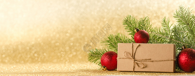 圣诞或新年装饰品,工艺纸礼品盒,冷杉树枝金色闪光的背景,圣诞礼物装饰品图片