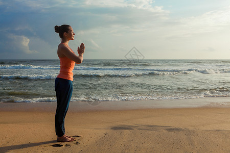 海滩上做阿什蒂加维尼亚萨瑜伽的女人女人海滩上做瑜伽高清图片