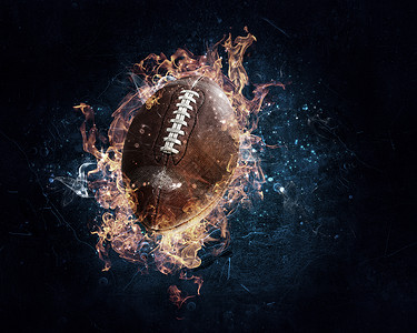 橄榄球黑暗背景下的火焰中美国足球比赛的背景图片