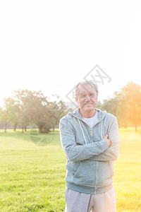 适合老人的肖像,站立的手臂交叉公园背景图片