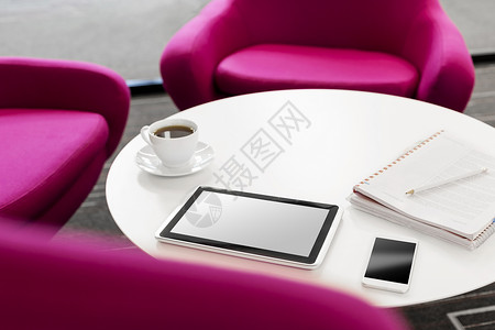 高角度的数字平板电脑与咖啡杯智能手机桌子上的椅子办公室图片