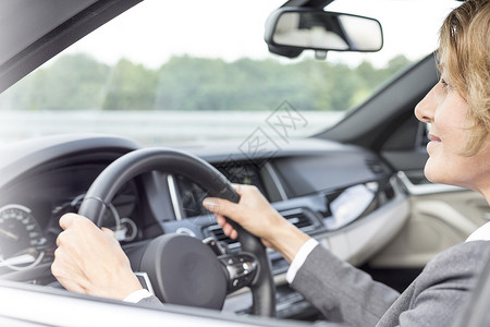 成熟的女商人旅途中驾驶汽车图片