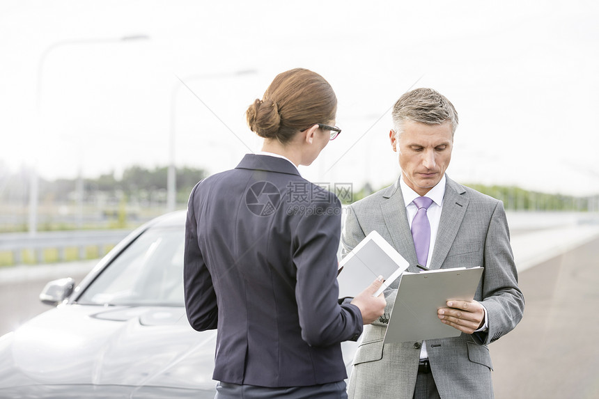 保险代理人与女商人讨论关于分解汽车的合同图片