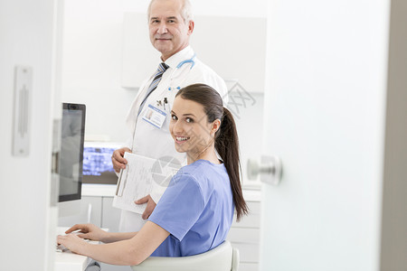 护士用笔记本电脑办公桌上与高级医生诊所的肖像图片