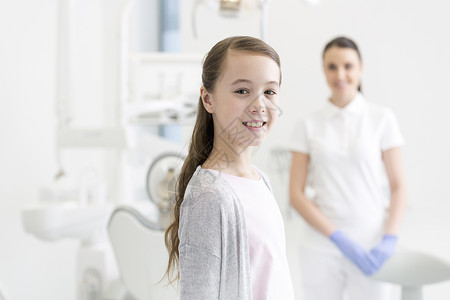 微笑的女孩病人诊所抗牙医的肖像图片