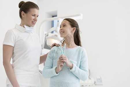 牙科诊所微笑的牙医带牙刷的女孩图片
