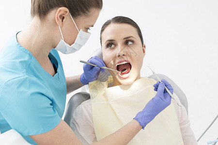 牙科医生牙科诊所用角镜定标器检查病人的嘴高清图片