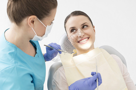 微笑的病人看牙医,诊所用角度镜定标器图片