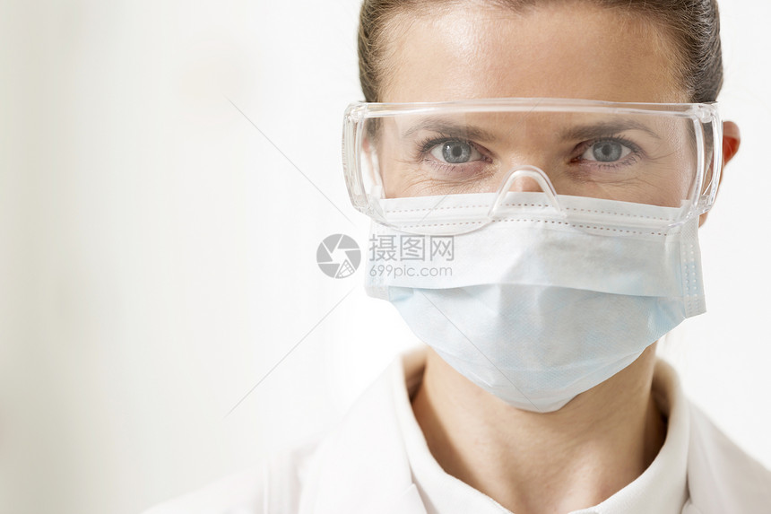 戴着外科口罩眼镜的自信牙医的特写照片图片