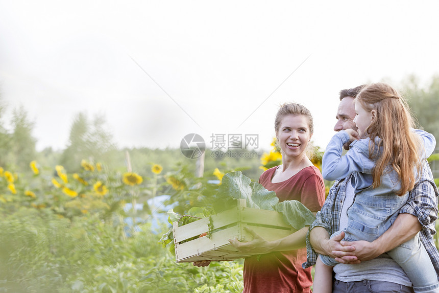 微笑的家庭带着蔬菜农场散步图片