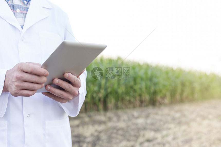 农场用数字平板电脑的成熟科学家的中段图片