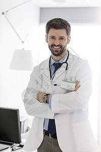 微笑自信的中年医生双臂交叉站医院图片