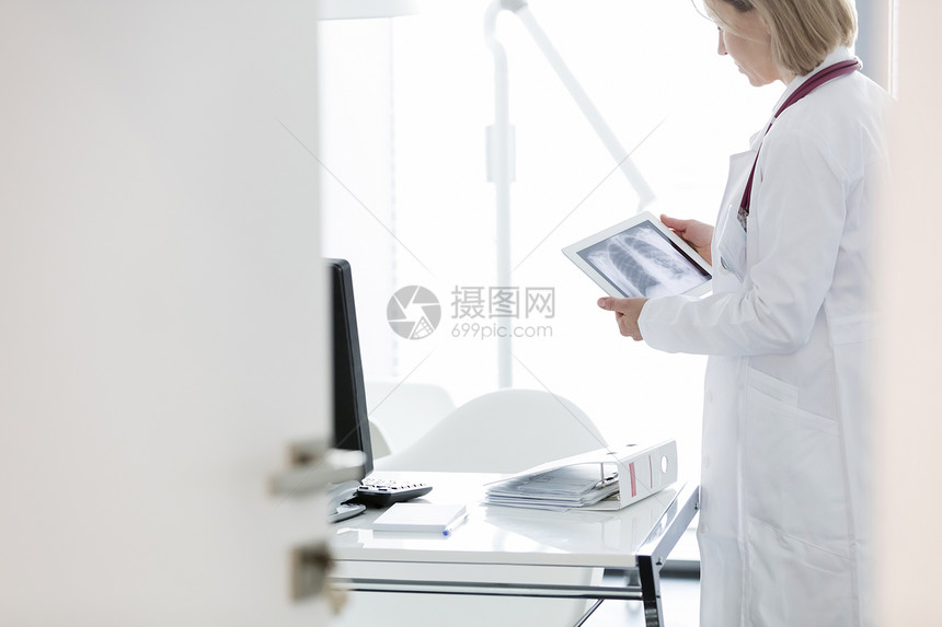 医生医院的办公桌前检查数字平板电脑上的X光图片