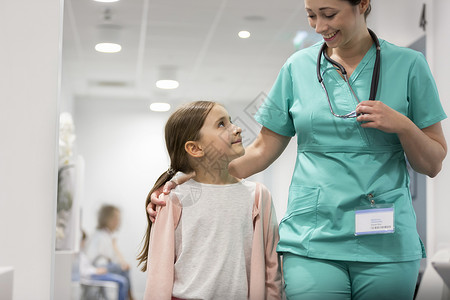 微笑的女孩医院走廊里散步时看着中等成人护士图片