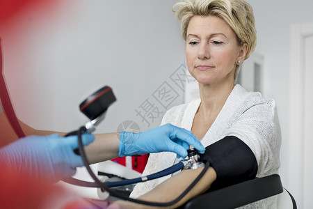 带手套检查医院病人血压的医生裁剪图像图片