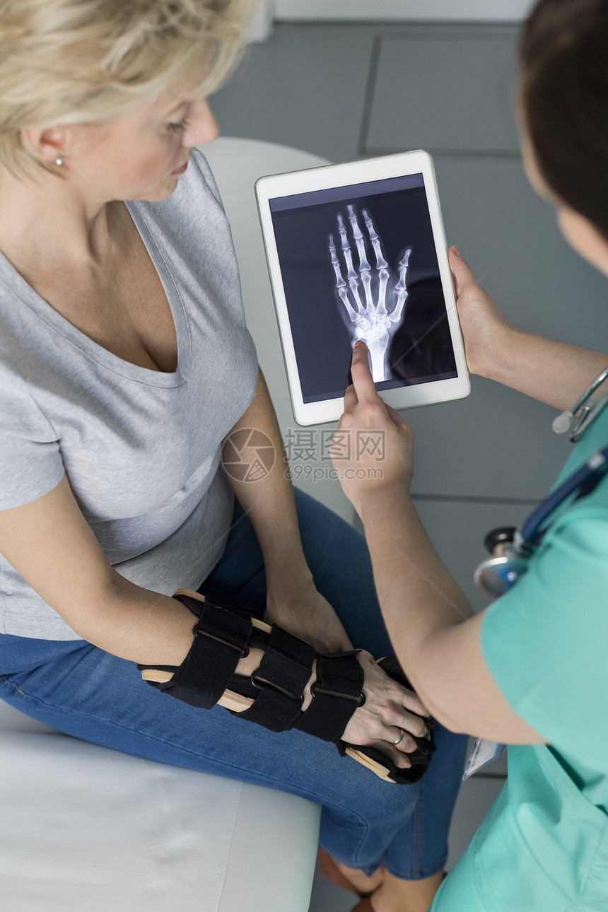 护士数字平板上向医院的成熟病人展示X光图片