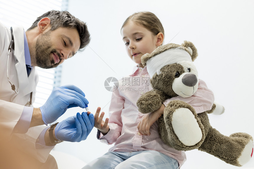 医生医院验血时用泰迪熊检查女孩图片