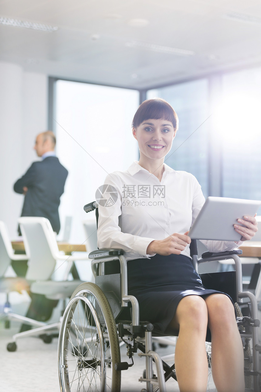 微笑的残疾女商人的肖像,坐轮椅上的数字平板电脑办公室图片