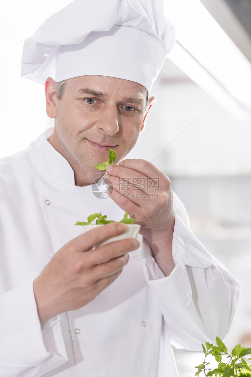 自信成熟的厨师餐厅餐厅厨房里的药草叶子图片