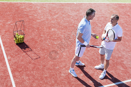 比赛中,站网球场上的男人交谈的全部长度背景图片