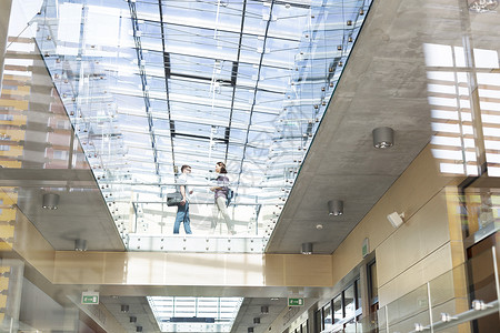 大学校园学生玻璃地板上行走的低角度视图图片
