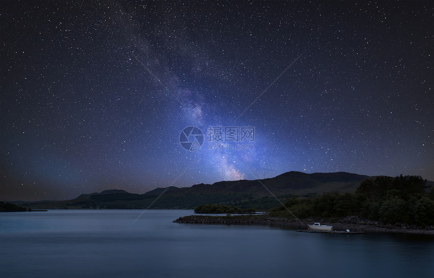 令人惊叹的充满活力的银河复合图像平静的湖泊景观与船岸上图片
