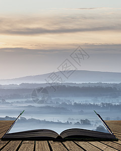 美丽的雾蒙蒙的英国乡村景观日出冬天,层层滚动田野里出来的神奇故事书页图片
