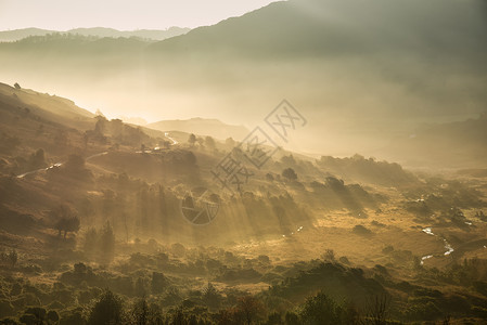 兰德尔阳光透过薄雾流入朗代尔山谷的日出湖区秋景图,背景