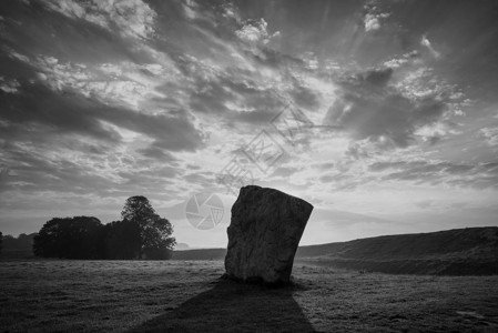 埃夫伯里美丽的黑白夏季日出景观的新石器时代站立的石头英国农村与华丽的光与背景雾背景