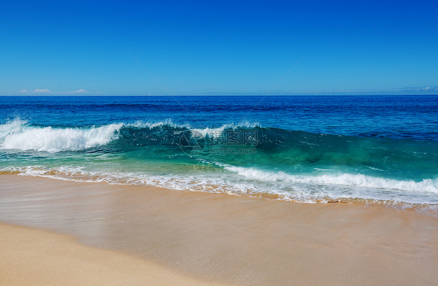海滩上的蓝色波浪模糊背景阳光斑点平的自然背景图片