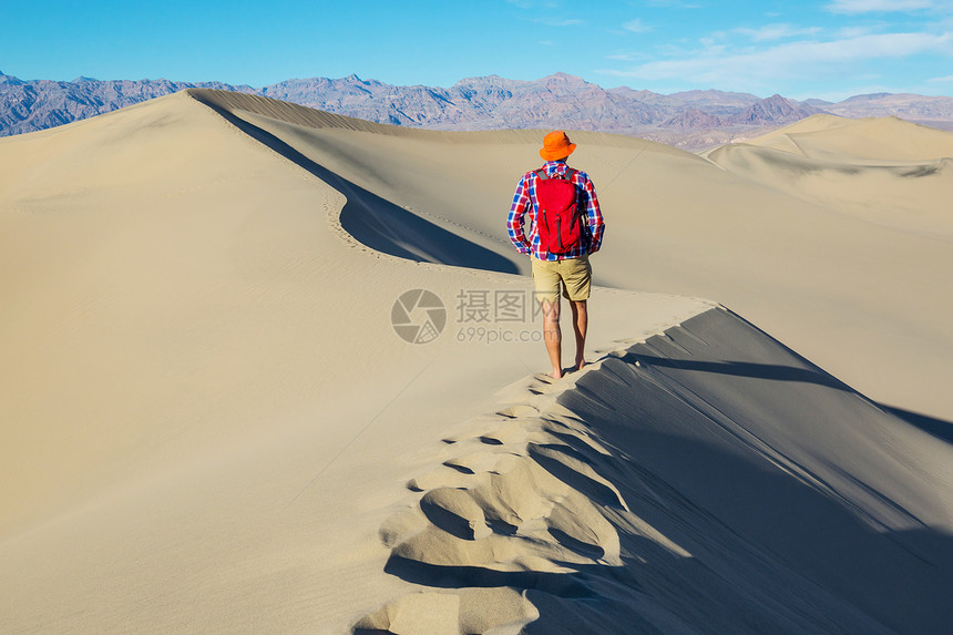 沙漠里的徒步旅行者日出时间图片