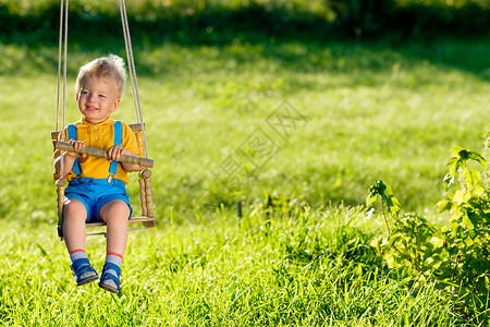 幼儿户外摆动的肖像农村场景与岁的男孩秋千健康的学龄前儿童暑期活动孩子外玩背景