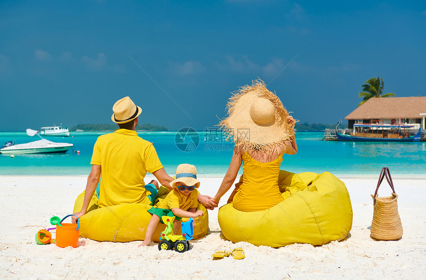 海滩上的家人,穿着黄色衣服的轻夫妇三岁的男孩马尔代夫的暑假图片
