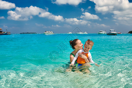 三岁的蹒跚学步的男孩海滩上母亲浅水中玩马尔代夫的暑假家庭假期图片