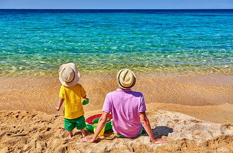 两岁的蹒跚学步的男孩父亲海滩上充气环海滩玩具暑假家庭假期希腊西索尼亚图片