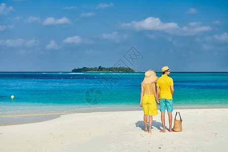 穿着黄色衣服的夫妇热带海滩上马尔代夫的暑假图片