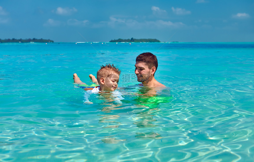 三岁的蹒跚学步的男孩学会父亲游泳马尔代夫的暑假家庭假期图片
